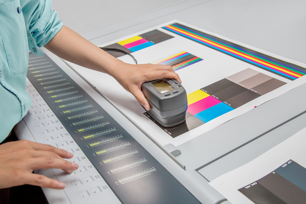 測色計で印刷物の色を読み込んで数値に変換している様子です
